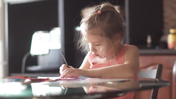 6 yaş çocuk evleri bir masada oturan çizer. sabah güneşi, küçük kız - Video, Çekim