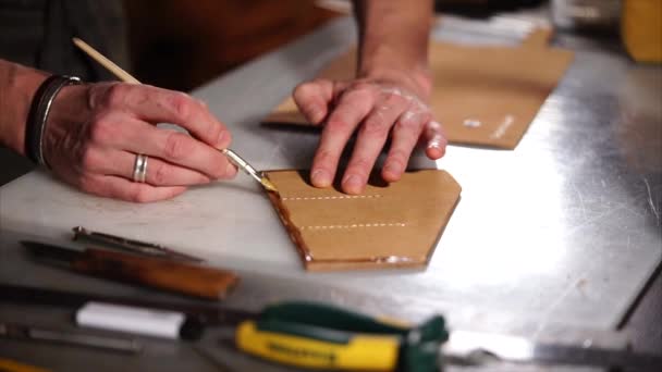 primer plano de las manos maestras, que unta la pieza de cuero en el taller
 - Metraje, vídeo