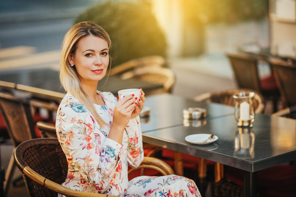 Retrato ao ar livre de mulher bonita descansando no café com xícara de café
 - Foto, Imagem