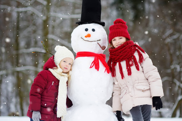 Pikkutytöt rakentaa lumiukko
  - Valokuva, kuva