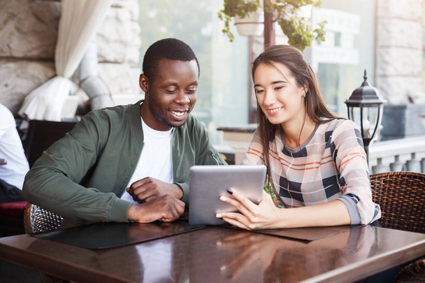 joven pareja usando tableta digital en la cafetería - Foto, imagen