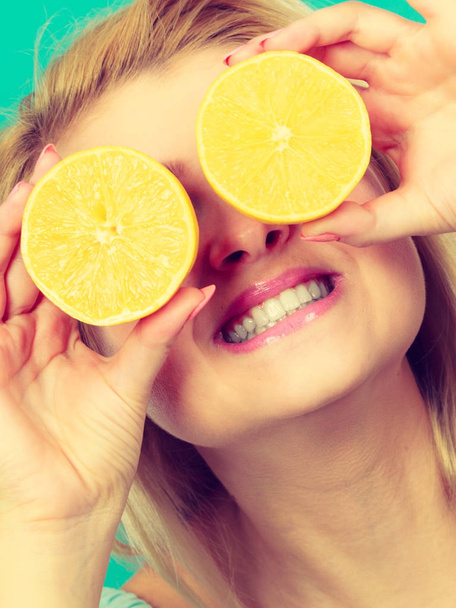 Girl covering her eyes with lemon citrus fruit - Photo, Image