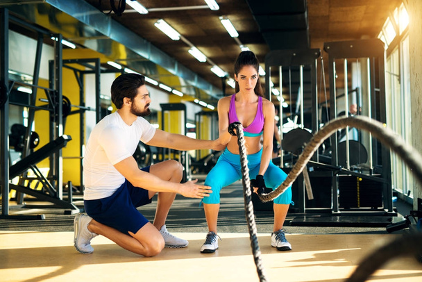 woman with personal trainer in gym - Foto, Imagem