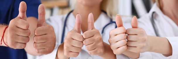 Група лікарів показують добре або підтверджують знак з великим пальцем вгору
 - Фото, зображення