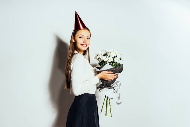 cute funny funny girl holding a bouquet of white flowers and smiling - Foto, imagen