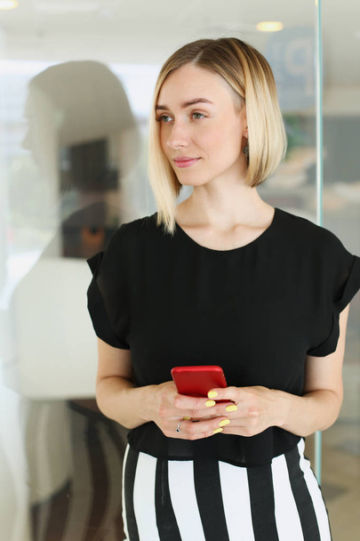 Business woman holding a smartphone in her - Fotoğraf, Görsel