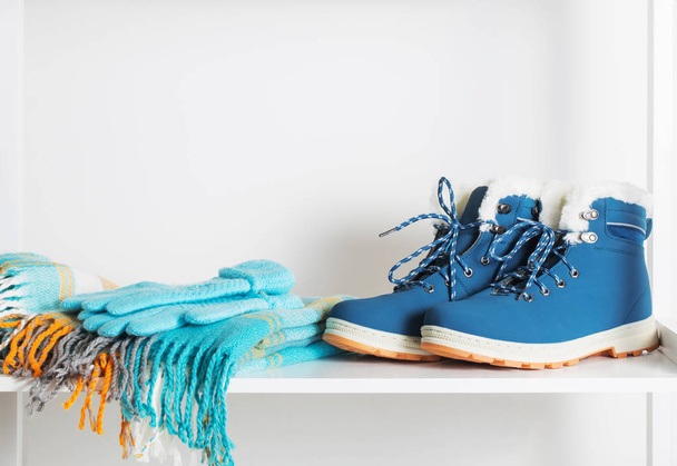 winter shoes, gloves and scarf on white wooden shelf - Foto, Imagem