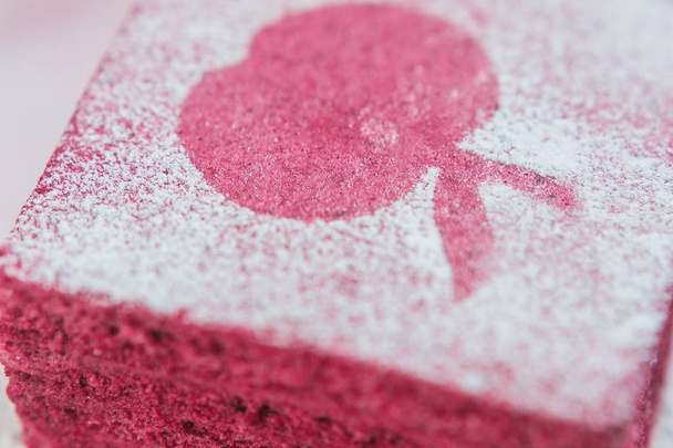 Pieza de pastila roja cubierta con polvo de azúcar vista macro
 - Foto, imagen