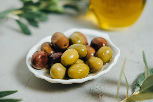 Organic Olives, oil and green branch on gray  background - 写真・画像