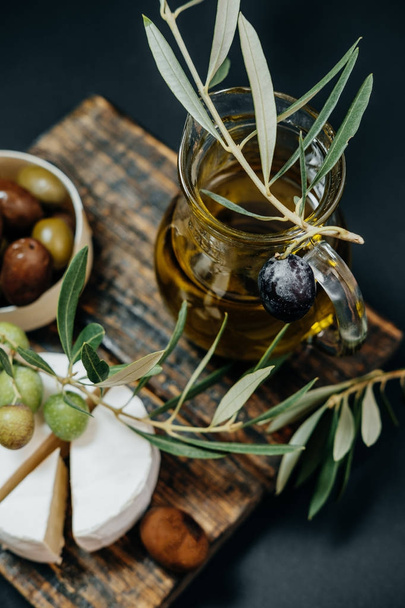 Healthy snack: Dark and green olives, oil, goat cheese on a wood - Foto, immagini