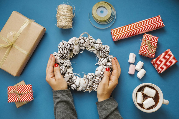 Frauenhände halten Kranz, heißer Kakao mit Marshmallows, Geschenke,  - Foto, Bild