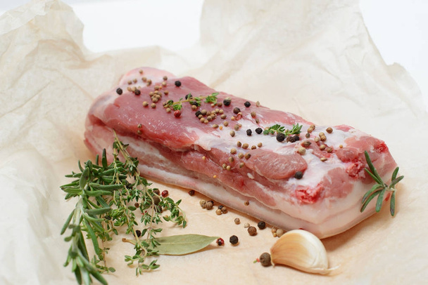 A piece of raw pork meat with herbs and spices - Foto, Bild
