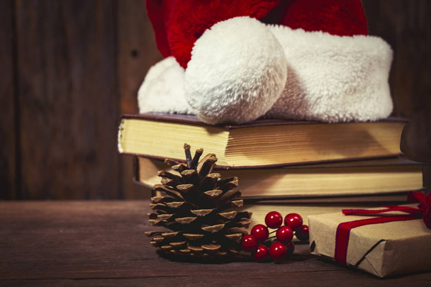 Chapeau de Père Noël, trois livres, boîtes avec un cadeau, un cône, une vibur
 - Photo, image