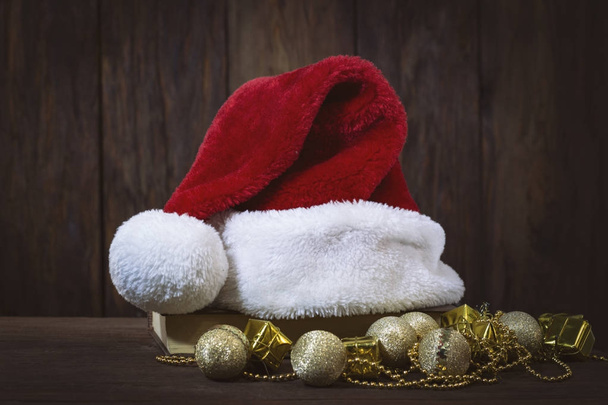 Санта Клауса капелюх на книги, золоті кулі, декоративних коробках і  - Фото, зображення