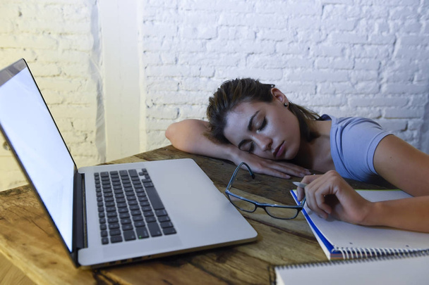 jeune belle et fatiguée étudiante fille dormir prendre une sieste couché sur ordinateur portable bureau épuisé et gaspillé passer la nuit à étudier
  - Photo, image