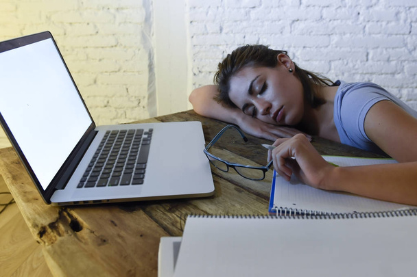 молода красива і втомлена студентка спить, лежачи на домашньому комп'ютерному столі, виснажена і марнує ніч навчання
  - Фото, зображення