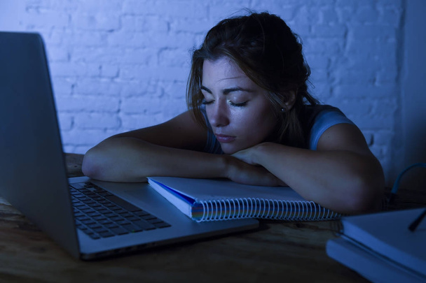 nuori kaunis ja väsynyt opiskelija tyttö nukkuu nokosilla makaa kotona kannettavan tietokoneen työpöytä uupunut ja tuhlaa yön opiskelu
  - Valokuva, kuva