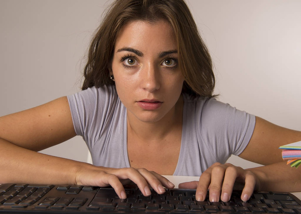 junge schöne Studentin oder arbeitende Frau, die auf der Computertastatur tippt und konzentriert und konzentriert in harter Arbeit aussieht - Foto, Bild