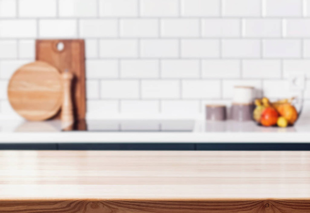 Wooden table in front of blurred modern kitchen. - Фото, изображение