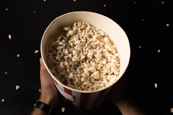 man bedrijf emmer popcorn - Foto, afbeelding