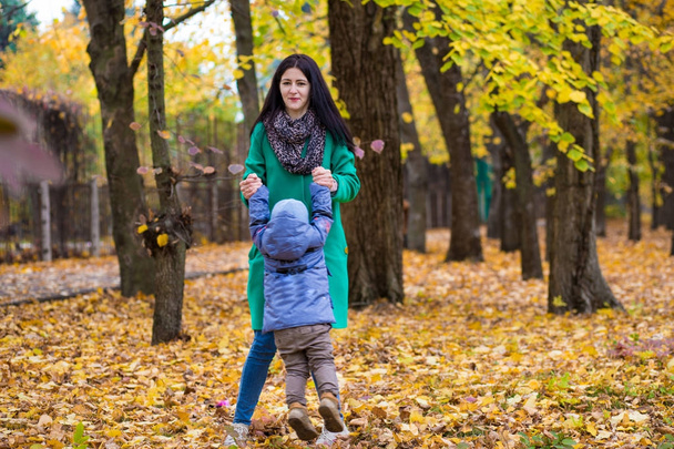 Madre con hijo pequeño juega en el parque de otoño
  - Foto, Imagen