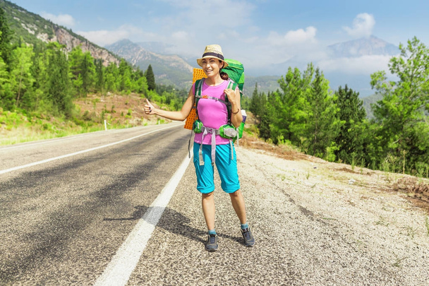 Happy Girl with hat and backpack hitchhiking on the road in Turkey, lycian way - Photo, Image