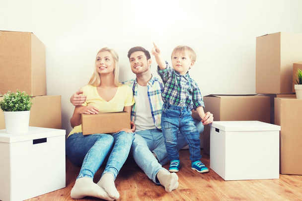 happy family with boxes moving to new home - Φωτογραφία, εικόνα