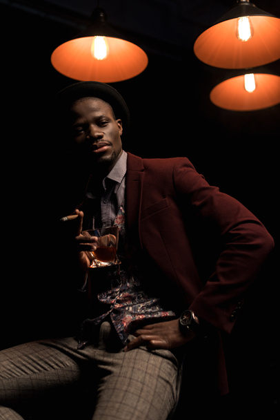modieuze Afro-Amerikaanse man met sigaar en whisky - Foto, afbeelding