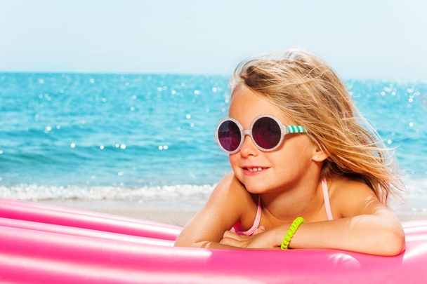 Girl sunbathing against blue sea - Fotó, kép