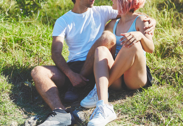 Happy man embracing his girlfriend sitting on grass - Zdjęcie, obraz