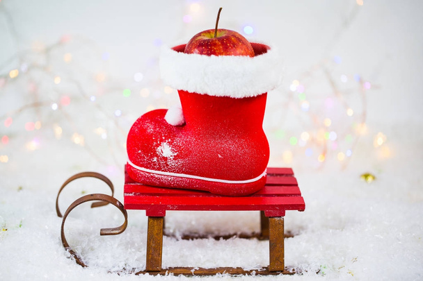 Санта-Клауса чоботи з горіхами, мандарини, яблука, на снігу - Фото, зображення