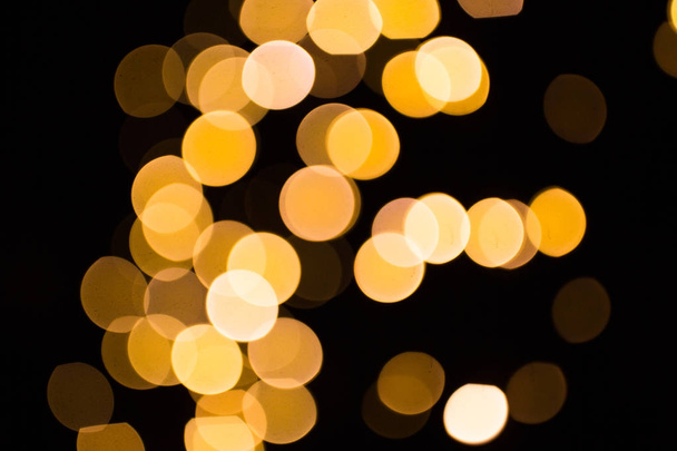 blurred golden lights over dark background - Fotó, kép