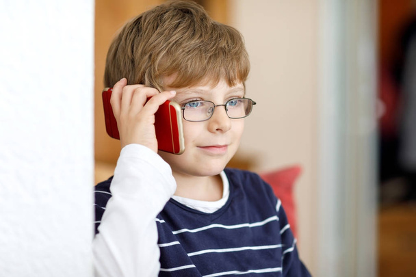 aranyos kis kölyök fiú szem szemüveg beszél a mobiltelefon - Fotó, kép