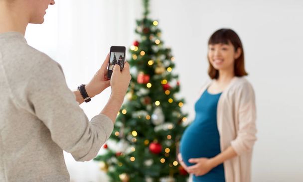 husband photographing pregnant fife at christmas - Φωτογραφία, εικόνα