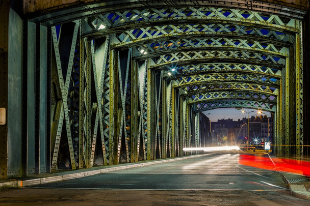 Asfalt silniční ocelové Rozestavěný most ve městě. Noční městské scény s světelné stopy aut v tunelu. Tónovaný - Fotografie, Obrázek