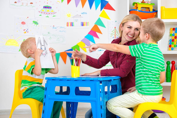 Children with mom and draw pictures in the kids room. - Photo, Image