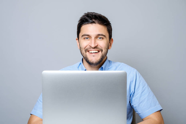 Homme heureux avec ordinateur portable isolé sur gris
 - Photo, image