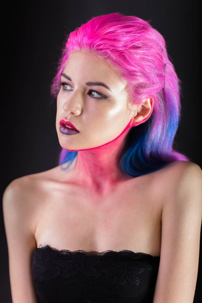 Portrait of attractive young woman with painted colorful hair looking away - Foto, Bild