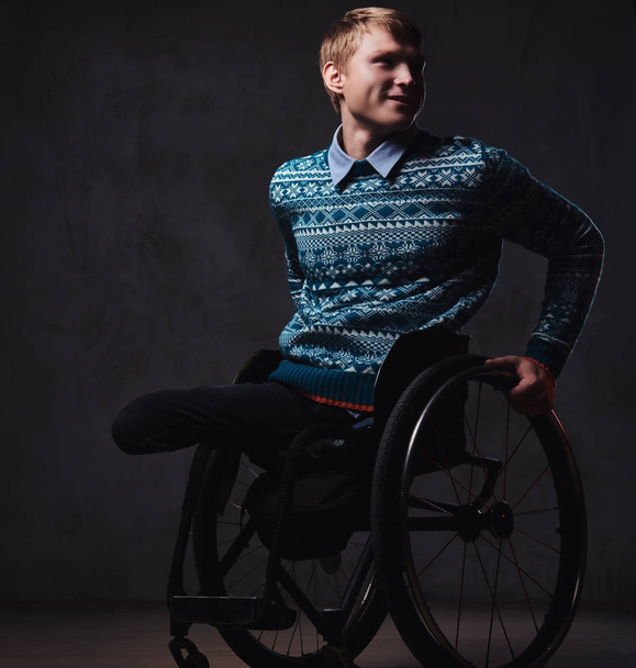 Человек в инвалидной коляске на сером фоне
. - Фото, изображение