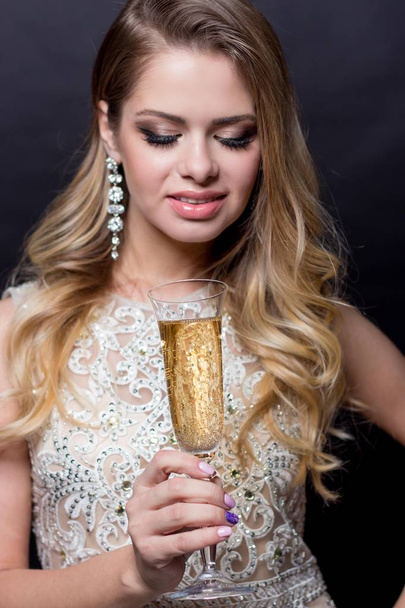 Retrato de uma bela jovem com uma taça de champanhe. Uma festa. Celebração. Natal, Ano Novo, Aniversário. Mulher feliz
 - Foto, Imagem