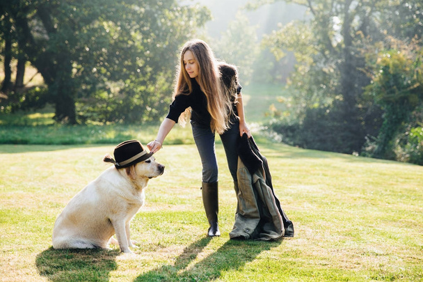 Mujer poniendo sombrero en el perro
 - Foto, imagen