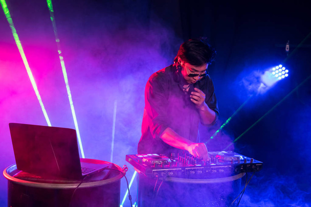 DJ είναι ρυθμό μουσικής με χειριστήριο και μίξερ. - Φωτογραφία, εικόνα