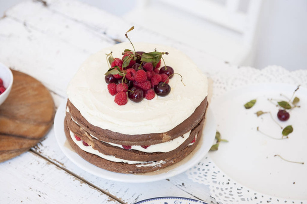 Cocoa Sponge Cake with Whipped Cream and Raspberries, cherries, - Photo, Image