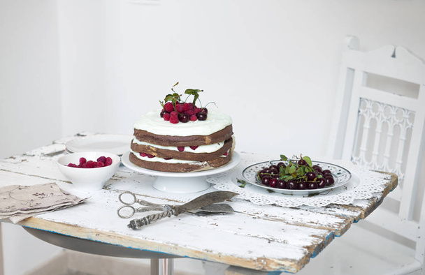 Какао бісквітний торт зі збитими вершками і Малина, вишні  - Фото, зображення
