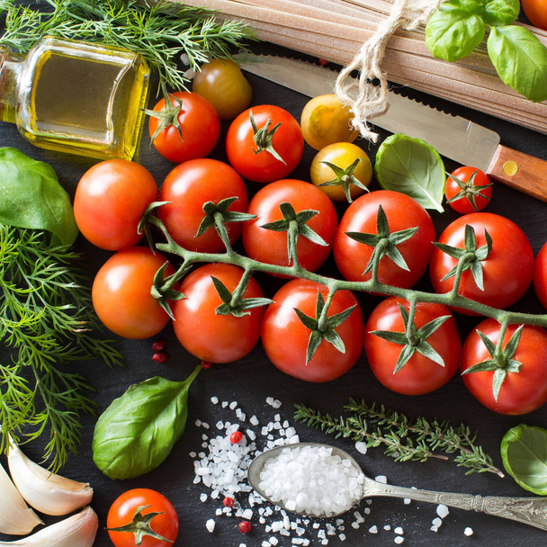 Ingredienti di cucina italiana: pomodorini, erbe aromatiche, pasta e
  - Foto, immagini