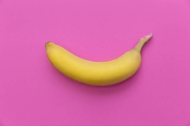 Yellow banana on pink background - Фото, изображение