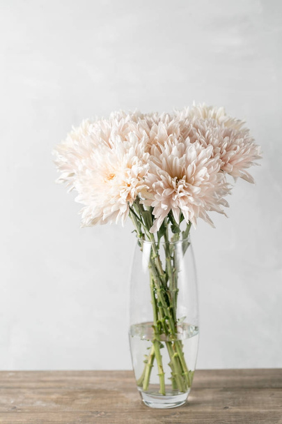 Vase with white chrysanthemum on a table of wooden planks - Photo, Image