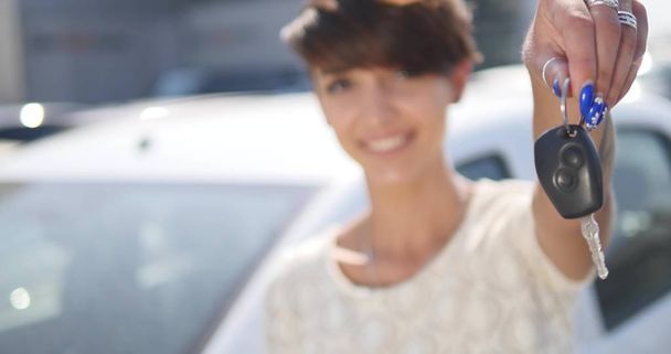 Young woman holding keys to new car auto and smiling at camera - Fotografie, Obrázek