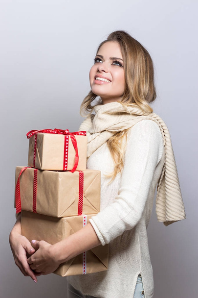 Young beautiful woman holding gifts. Happy girl holding gifts on white background. New Year. Christmas. Birthday. - Valokuva, kuva