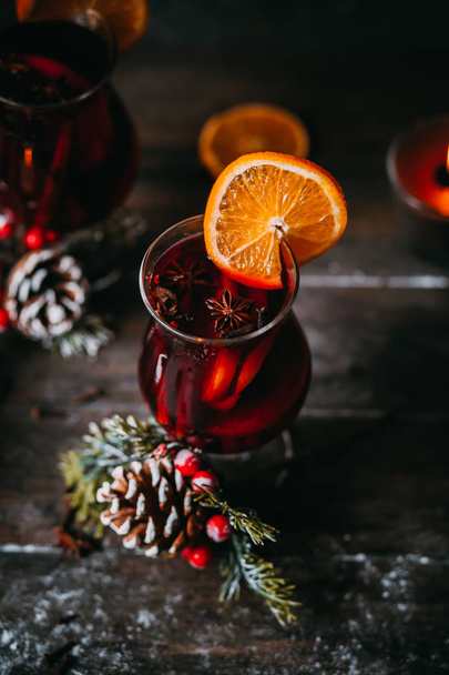 christmas hot mulled wine with spices, candle and traditional New Year decorations and orange on wooden background - Foto, Imagem